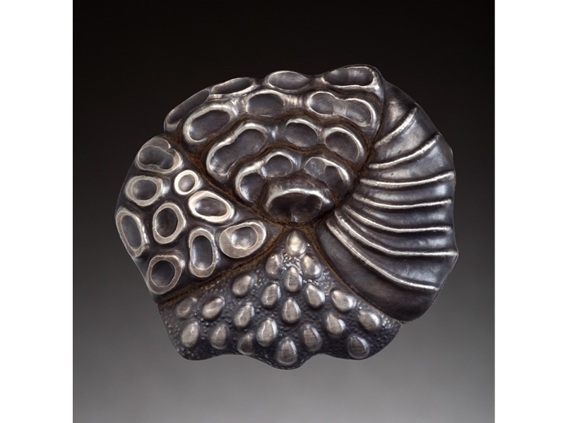 Nancy Mēgan Corwin, Quartered, 2013, brooch, sterling silver, chased, repoussé, fabricated, 57 x 57 x 13 mm, photo: Doug Yaple