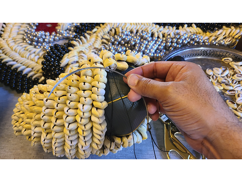 Demetri Broxton working with a leather needle to embellish the surface of Everlast boxing gloves, photo: Demetri Broxton