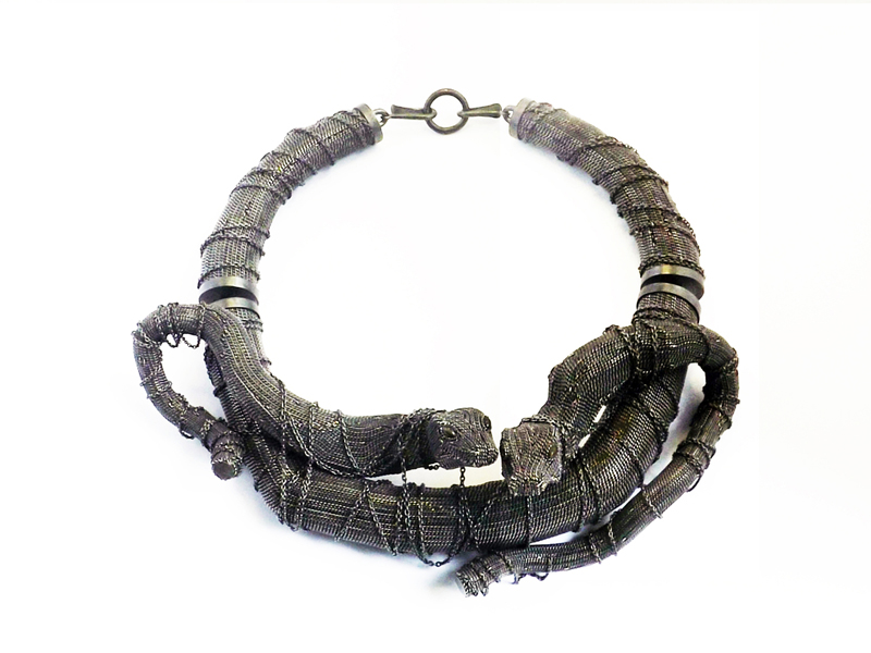 Terhi Tolvanen, Jungle Twins necklace from Jungle collection, 2014, silver, wood, hawk’s eye, 64 x 200 mm, photo: Mélina Borsetto Terhi Tolvanen, Jungle Twins necklace from Jungle collection, 2014, silver, wood, hawk’s eye, 64 x 200 mm, photo: Mélina Borsetto