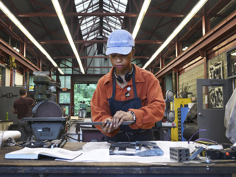 Shanti Broom working in the Penland iron studio, summer 2019, photo courtesy of Crafting the Future Shanti Broom