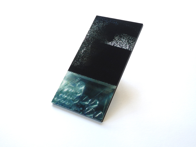 Margit Hart, Shifted Relations, 2012, brooch, photo on acrylic, silver, 118 x 60 x 3 mm, photo: Fritz Maierhofer Margit Hart, Shifted Relations