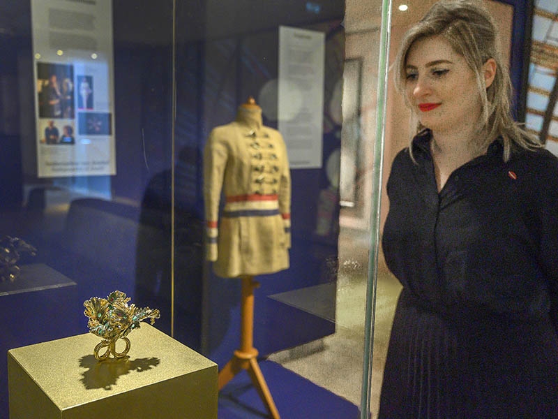 Exhibition view, Jewels!, 2019–2020, foreground work by Bibi van der Velden (Memento Mori, 2019, ring, gold, rubies, emeralds, pink sapphires, diamonds, mammoth tusk, 2019), background work by Jan Taminiau (post bag jacket, 2005), Hermitage Amsterdam, photo: Evert Elzinga/Hermitage Amsterdam Exhibition view, Jewels!, 2019–2020