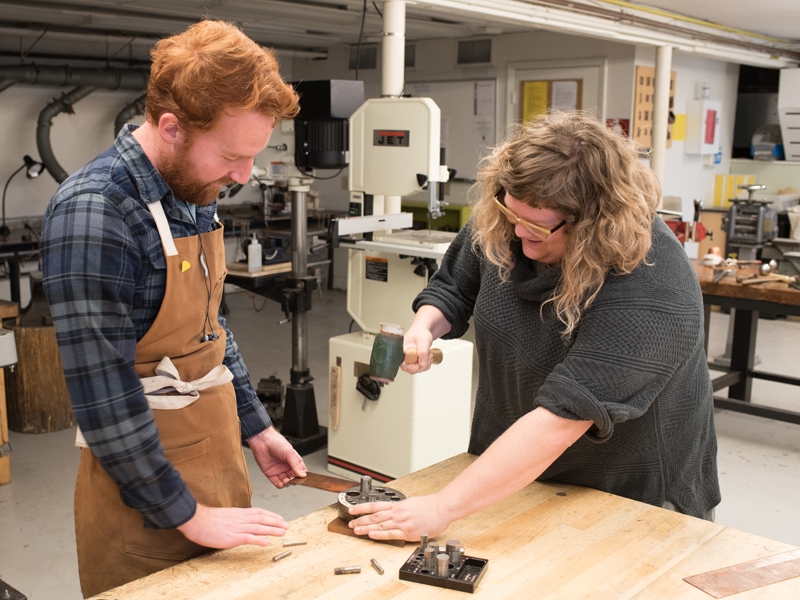 Resident artist Jaydan Moore helps printmaker Rebecca Henderson with a project in the Penland metals studio during winter residency, photo: Robin Dreyer Resident artist Jaydan Moore helps printmaker Rebecca Henderson