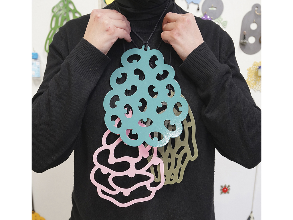 “Therefore, Zahra’s work occupies a space which is not easy to grasp or appropriate,” says Cranbrook’s Eichenberg. “It holds the tension of being and the confusing process of becoming rather than feeding into the need of clichés and simple answers. She places the viewer into the space of her exploration process, holding and not slipping into simple explanations for racial and cultural complexity. Her material/technical languages therefore are diverse, non-hierarchical, and fluent in all classes. Follow her and her conversation, as she will be a voice for the field and a generation.” | Zahra Almajidi, Where Are YOU From?: Surveillance (Select Objects), 2021, necklaces, brass, powder coating, silk cord, dimensions variable, photo: Bonnie Xue Where Are YOU From?: Surveillance (Select Objects)