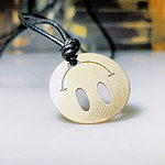 The smile on Sano Teruyuki’s Happy Charm looks upside down at first. But it’s positioned so that the wearer can see the smile when looking down. The smile will cause the wearer to smile. When the wearer smiles, that makes other people smile. | Sano Teruyuki, Happy Charm, 2021, pendant, brass, photo: artist