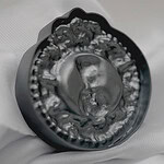 Tatjana Kutsõk, from the <em>Masquerade</em> series, 2024, brooch in silver, die-pressed cameos from CNC-milled aluminum molds, photo courtesy of the artist | The <em>Masquerade</em> series captures the idea of AI-generated self-portraits in the form of cameos as a representation or imitation of identity. The term "masquerade" implies a disguise or a performance, suggesting that the AI self-portraits are not authentic representations of self but rather constructed identities. This aligns with the concept of simulacrum, where the AI's representation of identity is simulated rather than genuine. The identity of artificial intelligence is characterized by constant change, mirroring the iterative nature of its learning algorithms.