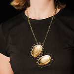 Jasmijn Van Hoof, <em>Cycle,</em> 2024, necklace in gold-plated copper and silver, photo courtesy of the artist | The locket, traditionally used to commemorate loved ones, holds a special place within this body of works. We’re all familiar with lockets. They hold a portrait inside to remind us of a loved one and to keep the memory alive. This locket is empty inside. It can be closed but not locked. It references the continuous cycle humans go through of memories being stored in our brains and then “falling out” or being forgotten. The locket has no lock to show the constant falling open and the confrontation with an empty interior. It reminds us that forgetting is not necessarily something to fear, but rather something to embrace as a natural part of life.