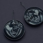 Tatjana Kutsõk, from the <em>Masquerade</em> series, 2024, earrings in silver, die-pressed cameos from CNC-milled aluminum molds, photo courtesy of the artist | Although the self-portraits created by AI provide a glimpse into the self-awareness of algorithms, they still lack genuine consciousness. Challenging our understanding of identity and the moral implications of attributing human characteristics to non-conscious entities, they blur the lines between human and machine, prompting us to rethink the nature of identity and the role of consciousness in defining it.