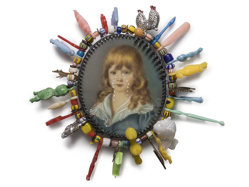 Geraldine Fenn, Colonial Comeuppance VI: Golden Boy, 2023, brooch in silver, vintage portrait, diamonds, glass, glass trade beads, vintage plastic charms, silk thread, steel pin, photo courtesy of the artist