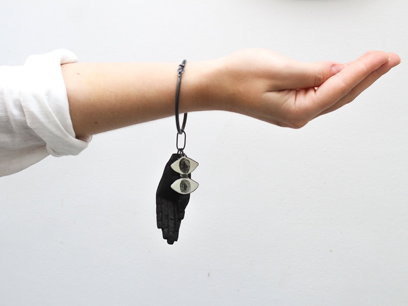 Iris Eichenberg (+Jimena Rios), Taurus III, 2025, bracelet in oxidized silver, enameled copper, wood, Chinese ink, 3 ⅛ x 1 ⅝ inches (80 x 40 mm), photo: Luana Ferreiro