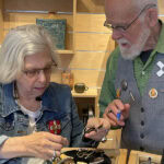 (Left) collector and AJF traveler Susan Lewin discusses Ebendorf’s work with (right) the artist, photo: Nathalie Mornu. For the past 25 years, Ebendorf has repurposed existing materials by devising ingenious uses for the discarded and discovering ways to make the used into the new. His conceptual approach to jewelry questions the nature of adornment itself and explores alternative materials and ideas about the preciousness of jewelry. He’s a co-founder and former president of the Society of North American Goldsmiths, and his art is represented in diverse collections, including the Met, the V&A, and the Yale University Art Gallery. He taught at East Carolina University (1998–2016), and now lives in Santa Fe.