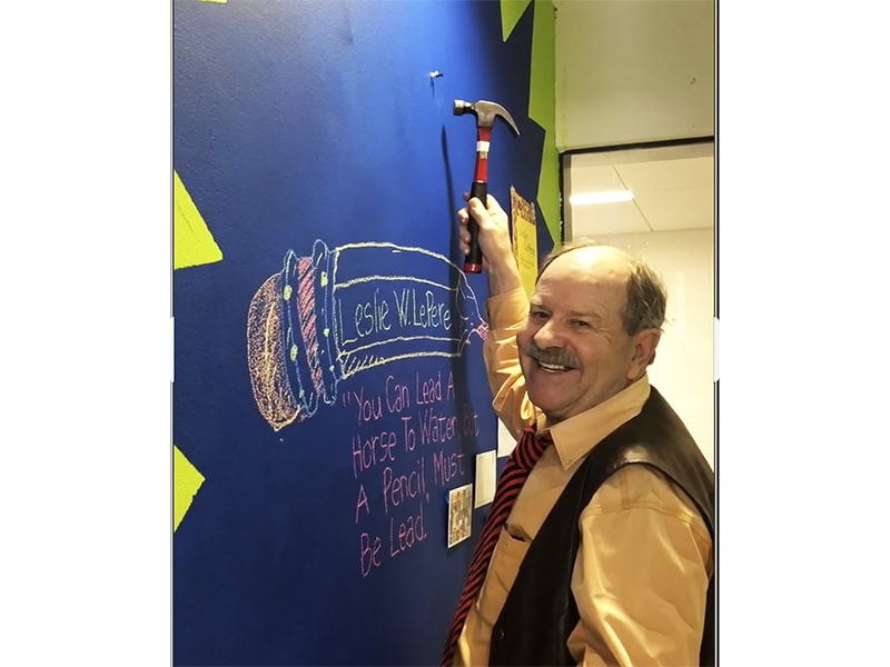 Les LePere installing artwork in a showcase during a visit to Western Michigan University,photo courtesy of Autumn Brown