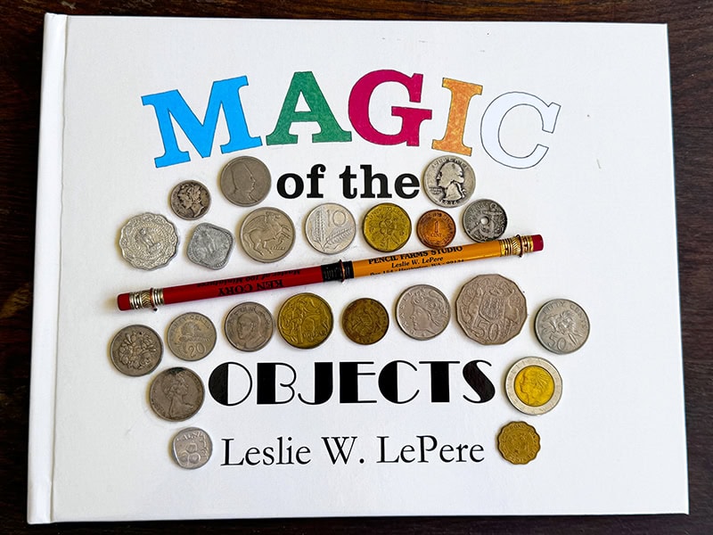 Book cover for Magic of the Objects, photo courtesy of Autumn Brown. This book was printed alongside a retrospective of Les’s work at the Jundt Art Museum, at Gonzaga University, in Spokane, WA, US, in 2013. Les left a blank space on the cover so that objects could be glued to the front. This one is covered with items from Ken Cory’s coin collection, as well as a commemorative Pencil Brothers pencil.