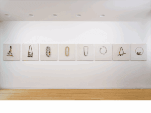 Sandy Grotta’s necklace collection displayed on the walls, photo drawn from craftcouncil.org