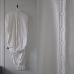 “I asked my mom and grandma to trace each other’s body outlines onto fabric and send them to me from China to the US,” says Yuan. “Using these shapes, I created works that speak to maternal protection—how care is embodied, passed down, and held across generations. This garment bag is made of my grandma's body shape traced by my mother.” | Caption: Ziqi Yuan, A Mother's Shape 母形, 2025, in cotton, plastic buttons, photo: artist