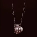 This glass necklace is part of a group that also consists of a ring and a brooch. “The work critically examines the reproduction of the female body in Western culture,” says Finck, “drawing on the recurring motif of the Three Graces and the symbolic decapitation of the head in art history. By referencing these canonical representations, the work highlights how bodies—and by extension, thought—have been subjected to persistent forms of restriction and control.” | Caption: Svea Finck, ReFLectME, 2025, necklace in glass, copper, thread, model: Rune Vervoort, photo: Saverio Sammartino