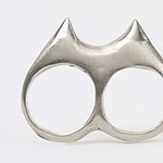“As a woman from Sonora,” says Codigo 23, “I have witnessed firsthand the effects of a culture that imposes limits and roles on women, minimizing their ability to defend themselves and be recognized as figures of power and respect. Inspired by this context, I chose the spur—an object of control and a symbol of male authority in the North—and transformed it into pieces of defense and protection, specifically designed for women.” ||| Codigo 23, Twin Impact, 2024, ring in lost wax, white alloy, 3.3 x 3.8 x 0.4 cm, photo courtesy of the artist