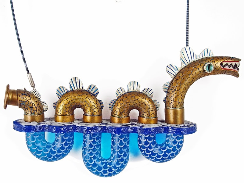 Lisa & Scott Cylinder, Scylla (Sea Serpent) Necklace, 2024, in various brass wind musical instrument tubes, sterling silver, aluminum, epoxy resin, tagua nut, acrylic, stainless steel, paint, fabricated, cast and carved, etched, necklace 20 inches (50.8 cm) long, pendant 3 ¾ x 6 ¼ x 1 ¼ inches (95 x 159 x 32 mm), wall panel 16 x 12 x 1 inches (40.6 x 30.5 x 2.5 cm), photo courtesy of Gravers Lane Gallery