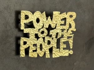 Shani Richards, Power to the People, 2026, brooch in brass, nickel, 2 ½ x 2 x ¹⁄₁₆ inches (64 x 51 x 2 mm), photo: artist