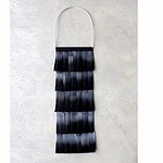 This necklace is made from collected wood pigeon feathers. Vervoort was drawn to the natural shifts in color within the material. By removing the recognizable form of a feather, the viewer is guided to see the material in a different way, allowing its details to come forward more strongly. By placing the altered feathers next to and beneath each other, a subtle, layered gradation emerges. Feathers serve as protection against weather conditions and external influences, but also as decoration and as a way of being seen. This duality strongly resonates with Vervoort. As a young designer, she often finds herself on the boundary between protecting and accepting herself. | Rune Vervoort, Verenkleed, 2026, necklace in feathers, fabric, brass, silver, photo courtesy of the artist