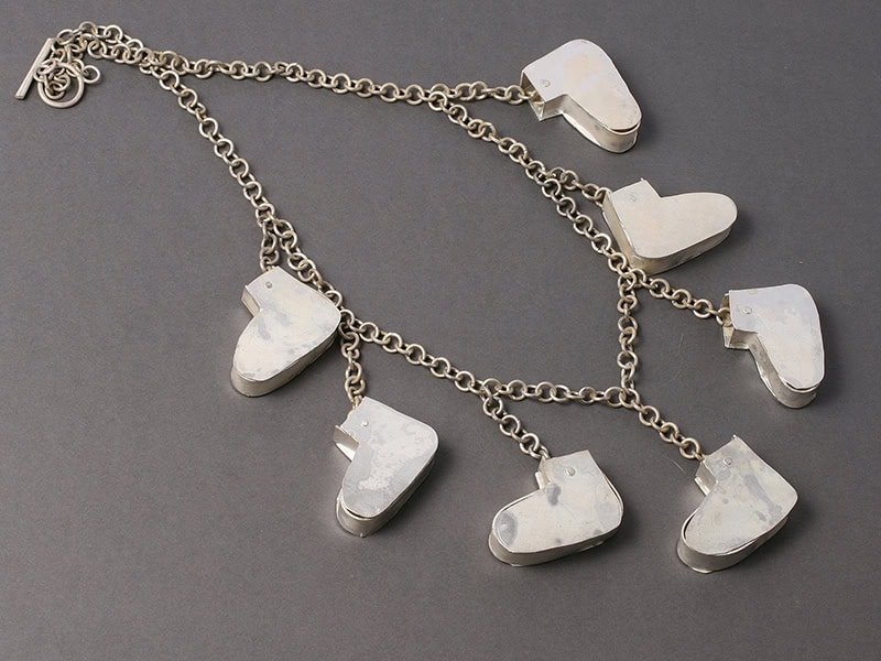 Lisa Walker, Dirk’s Shoes, 2019, necklace in sterling silver, one boot: 1 ⅝ x 1 ⅛ x ¹⁄₃₂ inches (40 x 30 x 1 mm), 23 ⅝ inches (600 mm) long, photo: artist
