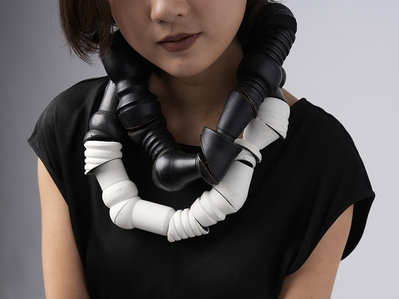 Ryan Seng, Noir Necklace, 2025, in wood, copper, stainless steel, 9 x 9 inches (22.8 x 22.8 mm), Limoges Porcelain Necklace 1, 2025, in porcelain, satin ribbon, 9 x 72 inches (22.8 x 182.9 cm), photo: Eric Perry