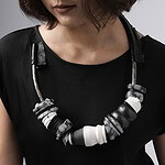 Seng considers each piece of jewelry like a carefully crafted ensemble. The many materials must combine to create a beautiful visual while at the same time eliciting a sense of tension and sensuality. The jewelry tempts the viewer, eliciting a desire to touch and feel it against their skin. Through unexpected combinations of materials such as horsehair, rubber, obsidian, and ebony, a seduction can begin. | Ryan Seng, Idar Obsidian Necklace, 2026, in brass, snowflake obsidian, porcelain, lambskin, 9 x 12 inches (22.8 x 30.5 cm), photo: Eric Perry