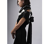 The Mementos series reflects the accumulation of experiences and materials Seng discovered over the last three years of his master’s program. In addition to material exploration, he is interested in how utilitarian objects in our everyday lives—things such as such as brushes, ribbons, and braids—function as ritualistic and intimate objects. In this photo, the model wears two necklaces. | Ryan Seng, Noir Necklace, 2025, in wood, copper, stainless steel, 9 x 9 inches (22.8 x 22.8 mm), Limoges Porcelain Necklace 1, 2025, in porcelain, satin ribbon, 9 x 72 inches (22.8 x 182.9 cm), photo: Eric Perry