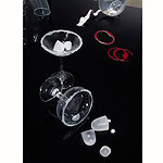 In Kupri’s work, a space emerges where ordinary details transform into precious stones, and the party itself becomes permanent. | Alice Kupri, Left to Be Forgotten, 2026, modified drinking glasses decorated with rims of crushed quartz; ice cubes carved from rock crystal; wine stains in the background made of enameled silver and tombac, photo: artist