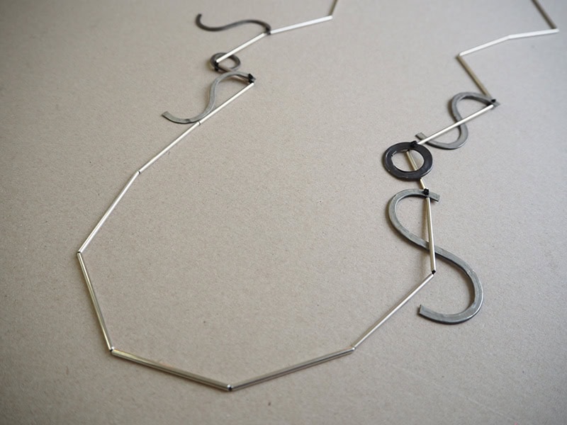 Linda van Niekerk, SOS Graffiti, 2026, neckpiece in sterling silver oxidized sterling silver, silk, 47 ¼ inches (1200 mm) long, chenier ¹⁄₁₆ inch (2.2 mm) in diameter, photo: Jane Bowden